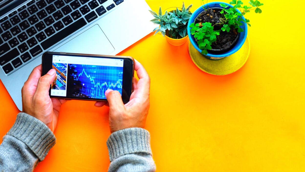 Zbliżenie biznesmena używającego telefonu komórkowego na stole