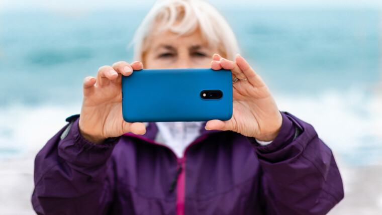 Turysta kaukaski blond kobieta robi zdjęcia lub nagrywa wideo przez telefon