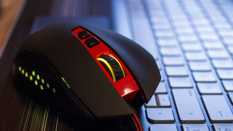Zbliżenie czerwonej i czarnej myszy komputerowej na klawiaturze laptopa na stole