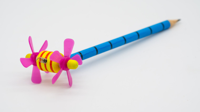 Zbliżenie ołówka i zabawki na białym tle