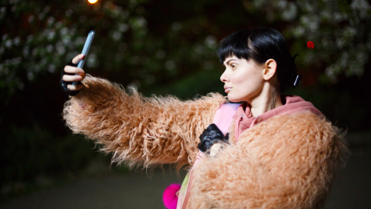 Piękna kobieta robiąca selfie w nocy.