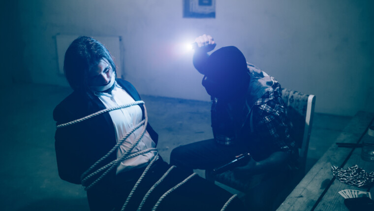 Ofiara siedzi na krześle. Jego ciało jest związane. Nie może patrzeć na swojego porywacza z powodu światła emitowanego przez małą żarówkę na czole zabójcy. Mężczyzna w masce siedzi przed swoją ofiarą.