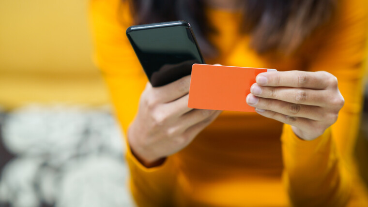 Środkowa część kobiety trzymającej telefon komórkowy