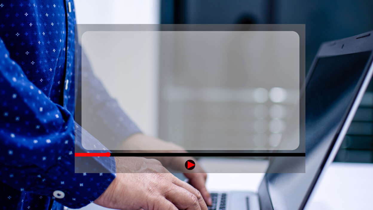 Mężczyźni stojący i piszący o filmie, korzystając z notebooka na białym stole