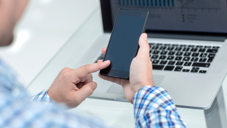 biznesmen, patrząc na ekran swojego smartfona