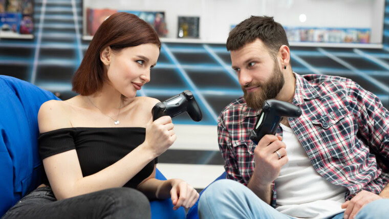 Portret wesołej, aktywnej pary grającej w gry wideo na playstation z kontrolerem konsoli w dłoniach, fani Xboxa