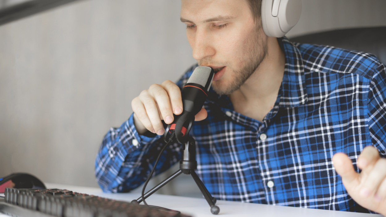 Młody, przystojny gospodarz nagrywa podcast w studio i transmituje na żywo