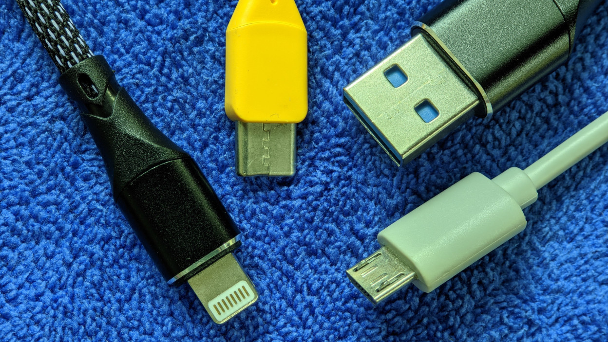 Zbliżenie różnych kabli USB na niebieskim tle