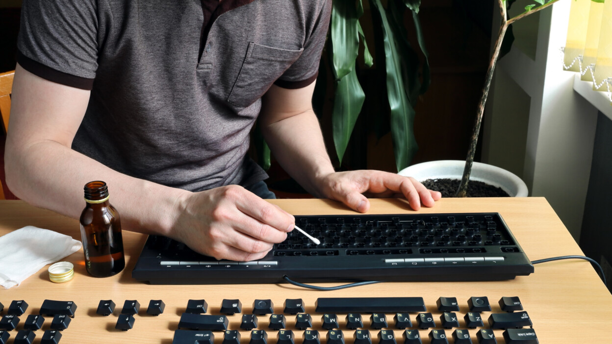 Mężczyzna zostaje w domu i dokładnie czyści zdemontowaną klawiaturę