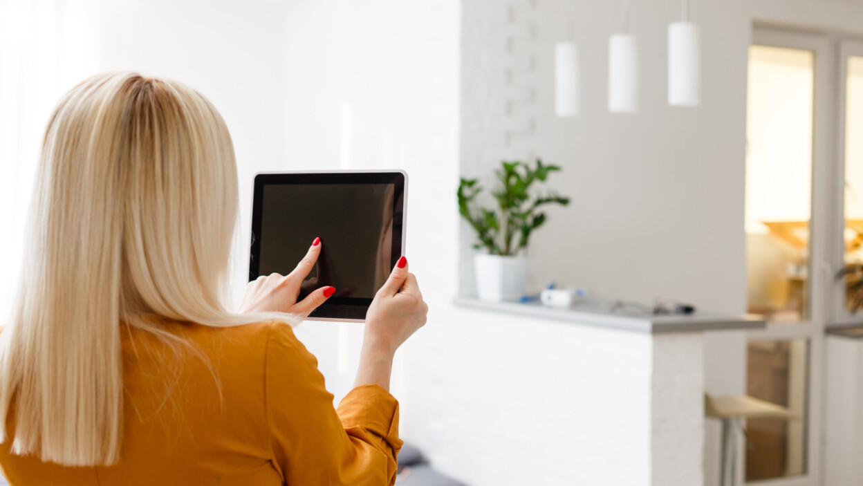 Uśmiechnięta młoda kobieta korzystająca z cyfrowego tabletu