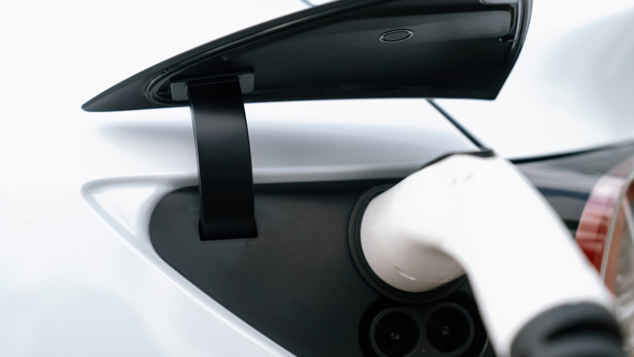 Zbliżony uchwyt wtyczki ładowarki EV przymocowany do synchronów portów pojazdów elektrycznych