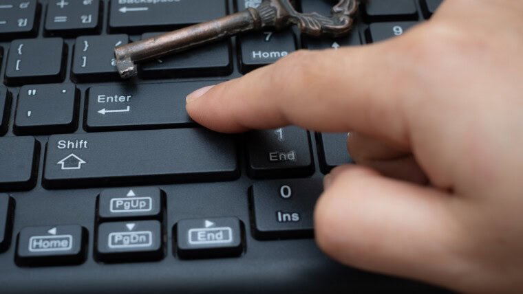 Zbliżenie żeński przycisk palca wskazującego Enter na klawiaturze komputera