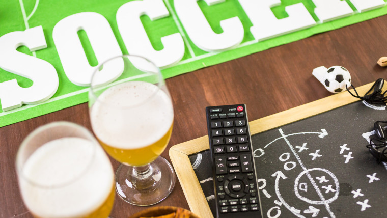 Słone przekąski i napoje na stole na imprezę piłkarską.