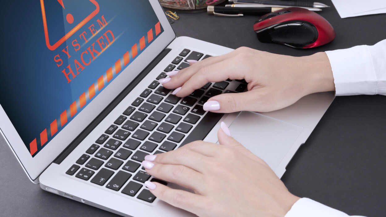 Kobiece dłonie z manicure na klawiaturze laptopa i ostrzeżeniem na ekranie komputera zhakowane Zdjęcie wysokiej jakości