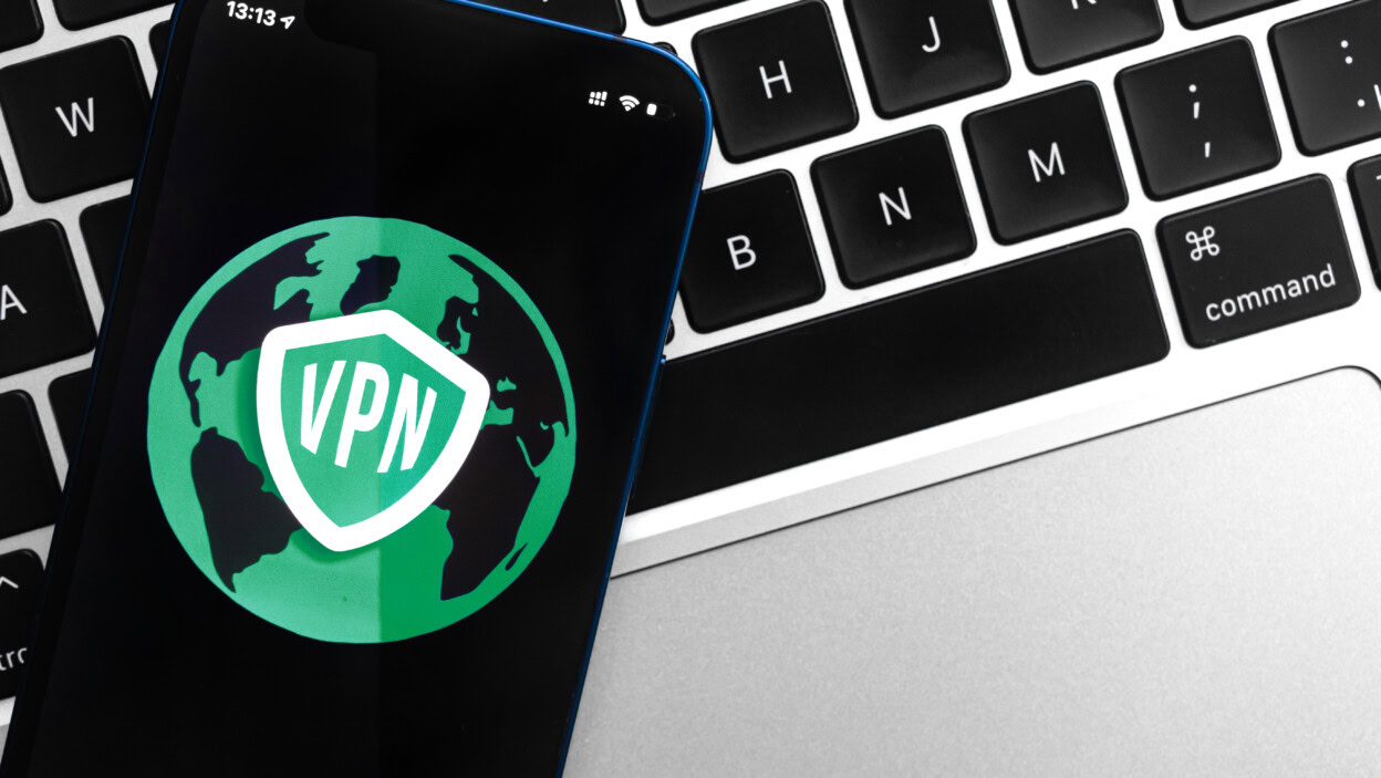 Koncepcja bezpiecznego dostępu do Internetu z VPN na smartfonie Anonimowy i bezpieczny Internet na telefonie komórkowym Pulpit z zdjęciem w tle technologii laptopa