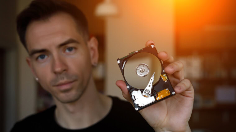 Mężczyzna trzymający w dłoni dysk HDD