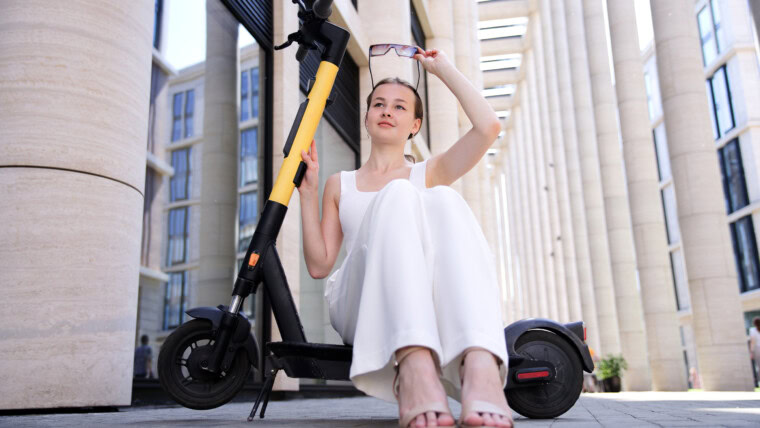 Młoda piękna szczęśliwa kobieta dziewczyna nastolatka jeździ na skuterze elektrycznym Electric eco udostępnianie transportu