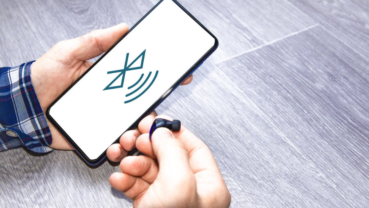 Mężczyzna łączący słuchawki bezprzewodowe z telefonem komórkowym