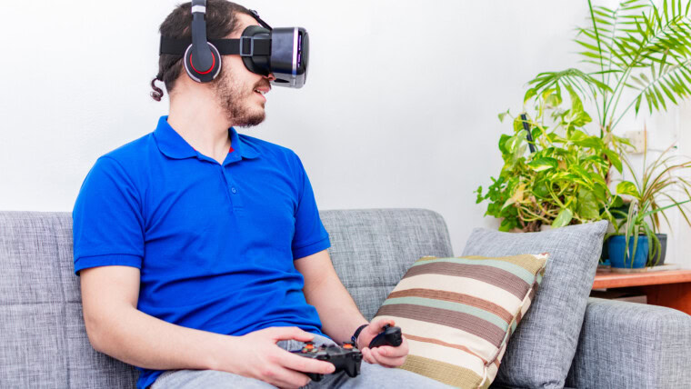 Mężczyzna grający w wirtualną rzeczywistość z goglami VR