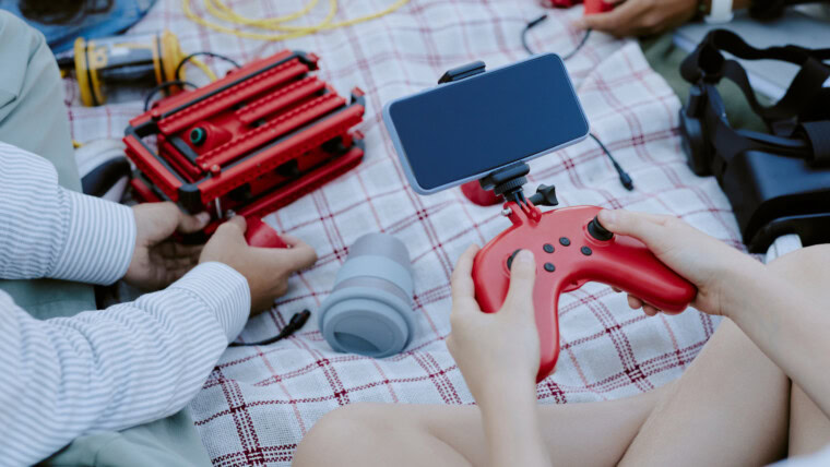 Nieznany dzieciak używający joystick i smartfona