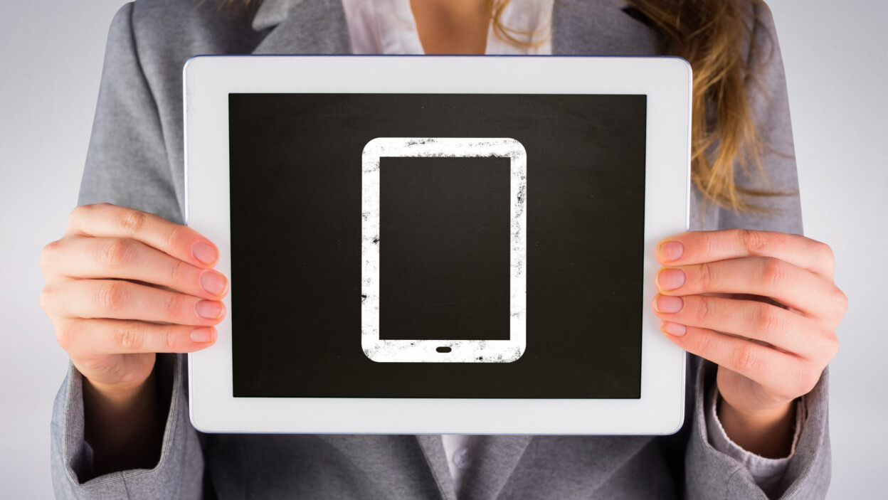 Bizneswoman pokazuje pastylkę przeciw szaremu tłu