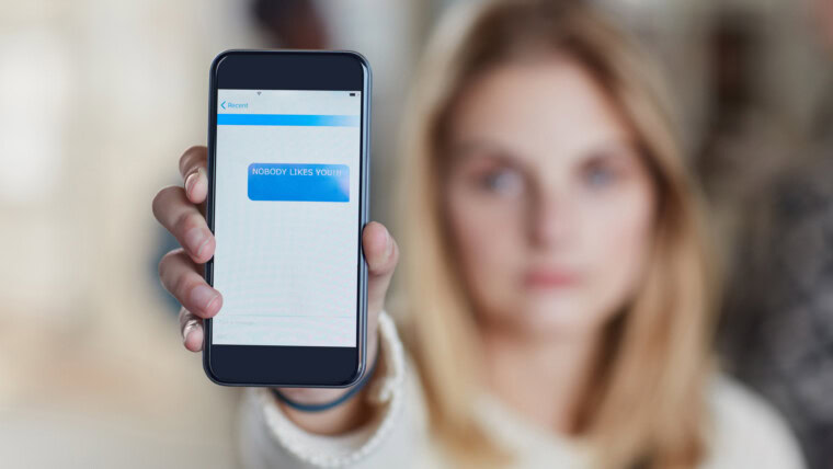 Hand phone screen and cyber bullying at university with social media stalker or notification at campus Person smartphone and rude chat with harassment mobile app and text message at college