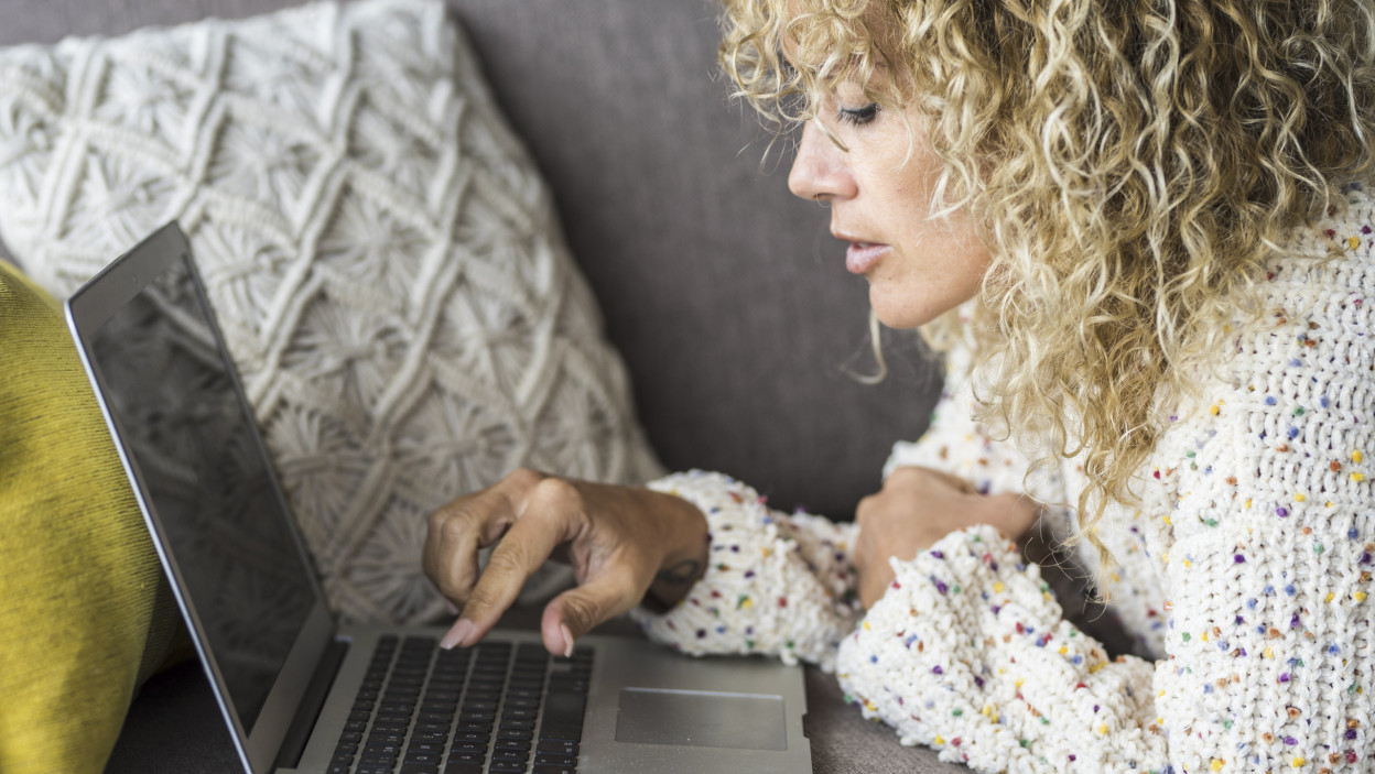 Randki online samotna kobieta Jedna nowoczesna modna kobieta pisze e-maile na laptopie w domu, wygodnie leżąc na kanapie w domu Ludzie korzystający z połączenia sieciowego i surfujący po sieci Technologia House