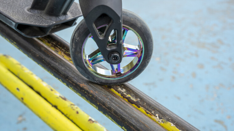 Hulajnoga wyczynowa na żółtej żelaznej rampie skateparku