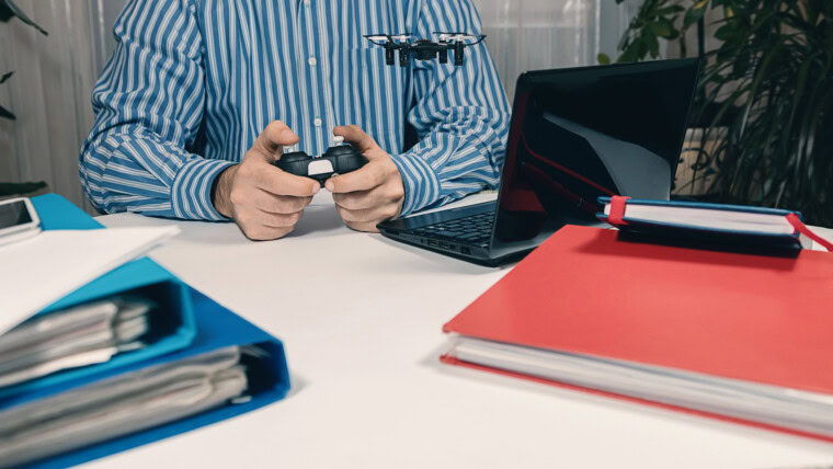 Biznesmen testuje nową zabawkę na biurku w biurze Gry pakietu office