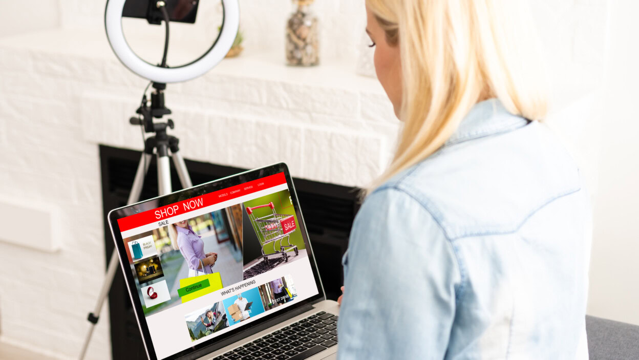Kobieta robi zakupy online za pomocą swojego laptopa w domu.