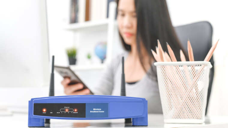 Bezprzewodowy router i kobieta używa smartphone w biurze