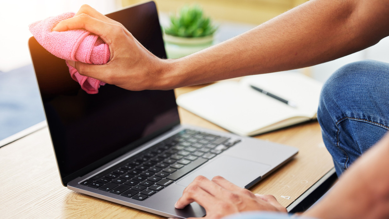 Higieniczny laptop i zbliżenie mężczyzny czyszczącego ekran, aby zapobiec zabrudzeniu kurzu lub zarazkom na biurku Technologia zdrowie i osoba płci męskiej wytrzyj komputer ściereczką do odkażania lub dezynfekcji w domu