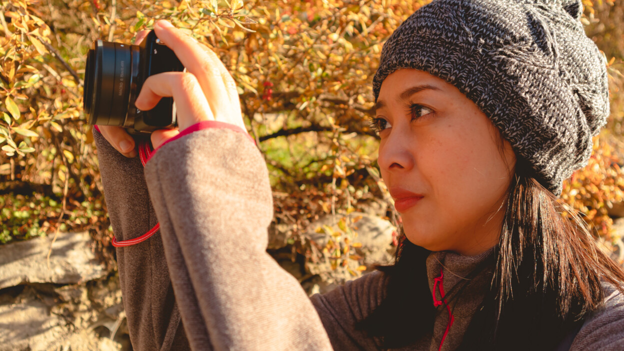 Turystyczna kobieta robi zdjęcie aparatem bezlusterkowym.
