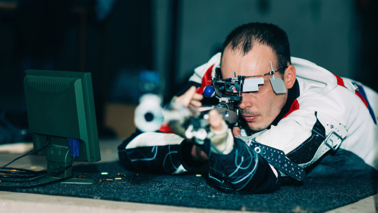 Mężczyzna trenujący strzelectwo sportowe, ćwiczący do zawodów z darmowym karabinem