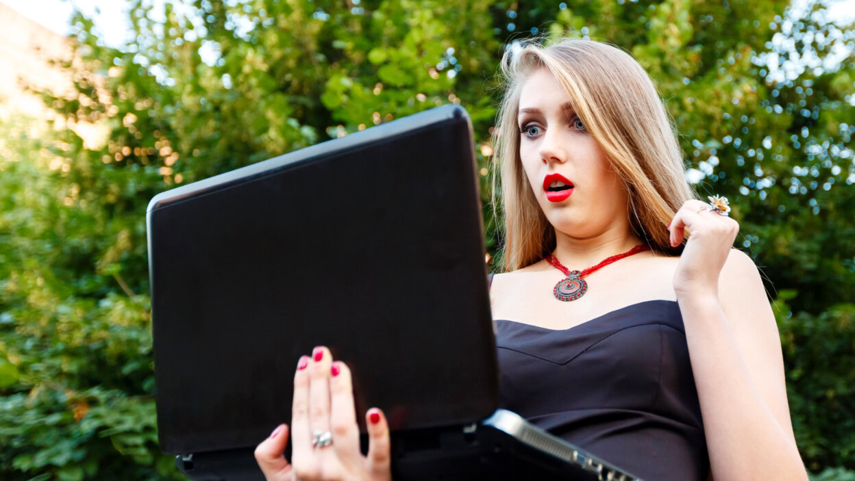 Piękna kobieta gapi się przy laptopem podczas gdy na drodze