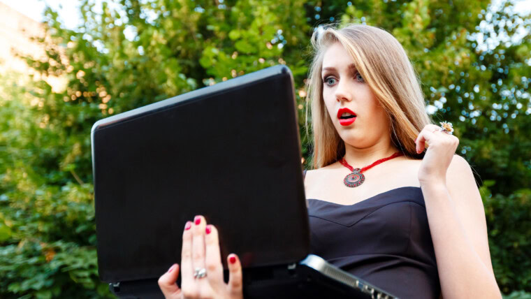 Piękna kobieta gapi się przy laptopem podczas gdy na drodze