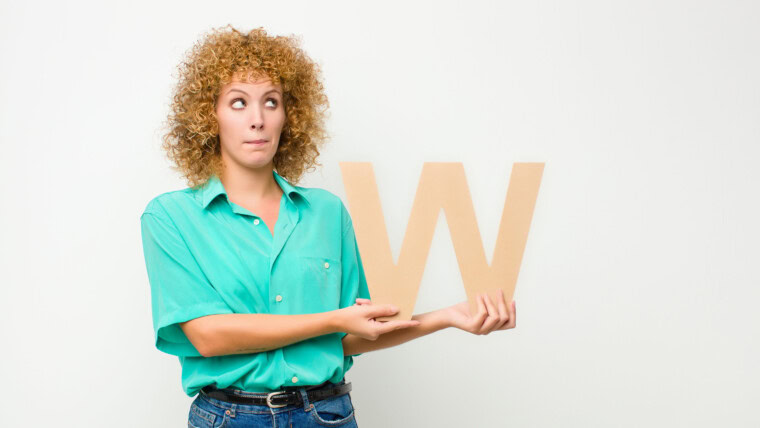 zaskoczony, zszokowany, zdziwiony, trzymając literę W alfabetu, aby utworzyć słowo lub zdanie.