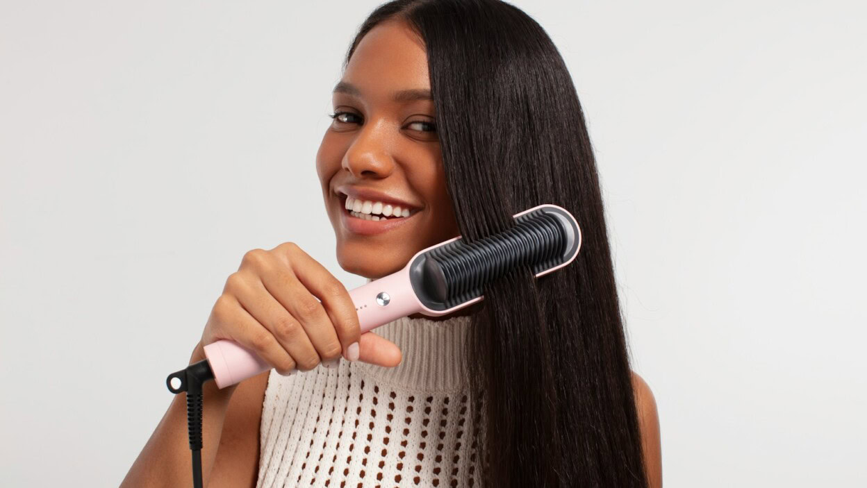 a woman using a hair dryer on her long hair