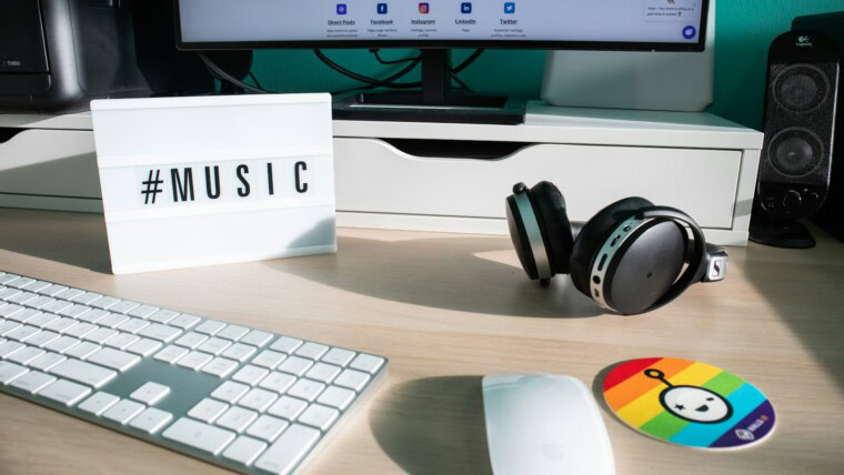 a desk with a keyboard, mouse and headphones