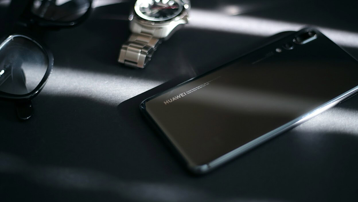 black samsung android smartphone beside silver round analog watch