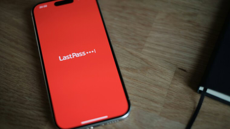 A red cell phone sitting on top of a wooden table