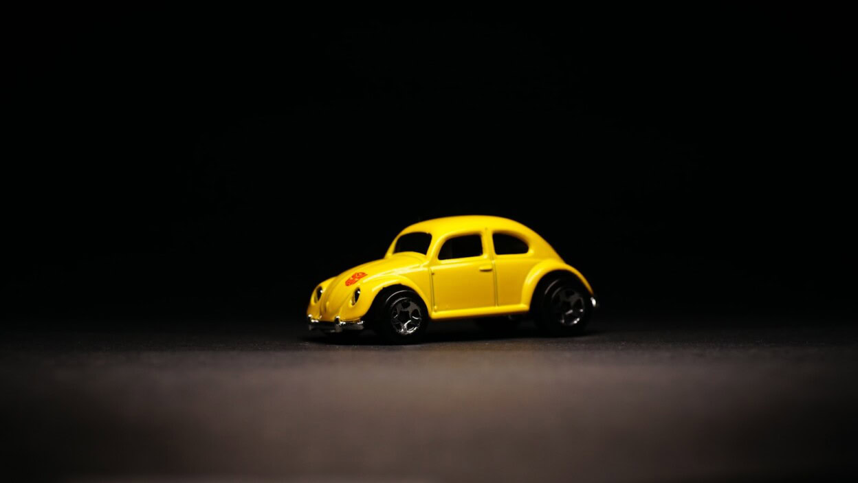 A yellow toy car on a black background
