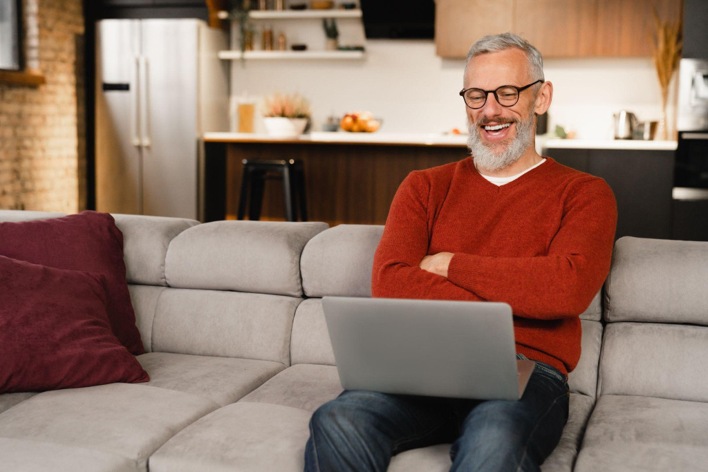 Uśmiechnięty człowiek z laptopem